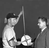 Mickey Mantle holds a tape measure with NY Yankees publicity director Red Patterson after Mickey hit a 565-foot home run at Griffith Stadium in Washington, DC on April 17, 1953.