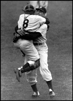 Yogi Berra hugs pitcher Don Larsen after pitching the only perfect game in World Series history. Mickey hit a home run and made a game saving catch to help Larsen make history.
